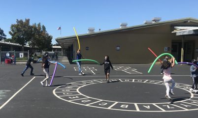 kids on playground with pool noodles